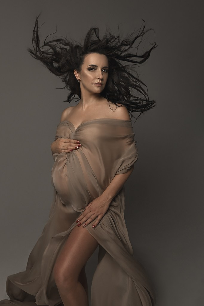 фотосессия беременной в фотостудии на темном фоне в красивом разлетающемся платье, фотография беременности, фотосессия беременных, портрет беременной