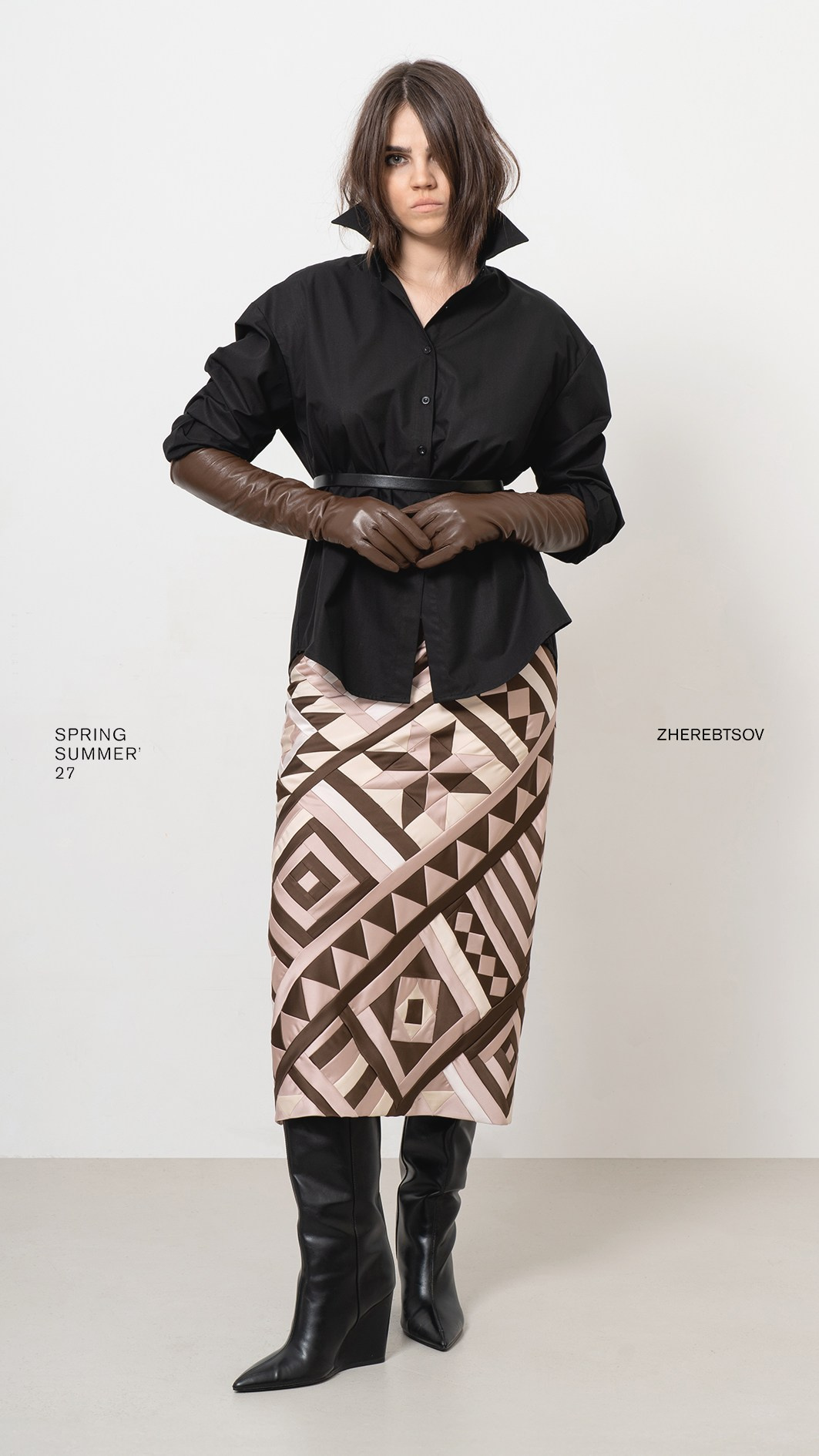 Lookbook коллекции ZHEREBTSOV — чёрная рубашка, коричневые перчатки и геометричная юбка в полный рост на светлом фоне