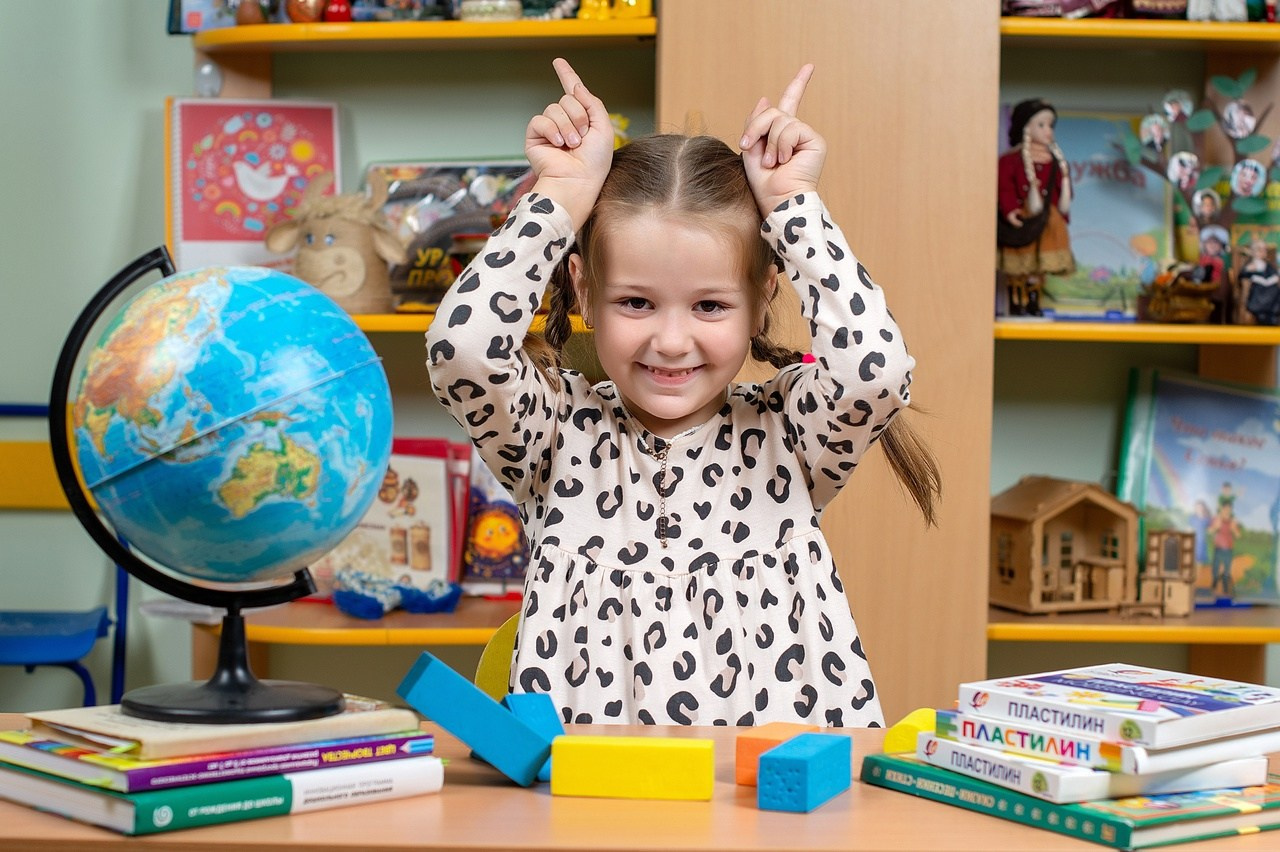 Девочка показывает смешные рожки на фотокамеру.