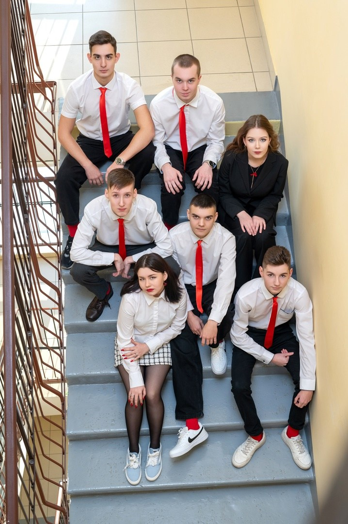 Ребята позируют на лестнице сверху вниз школьному фотографу в учебном заведении.