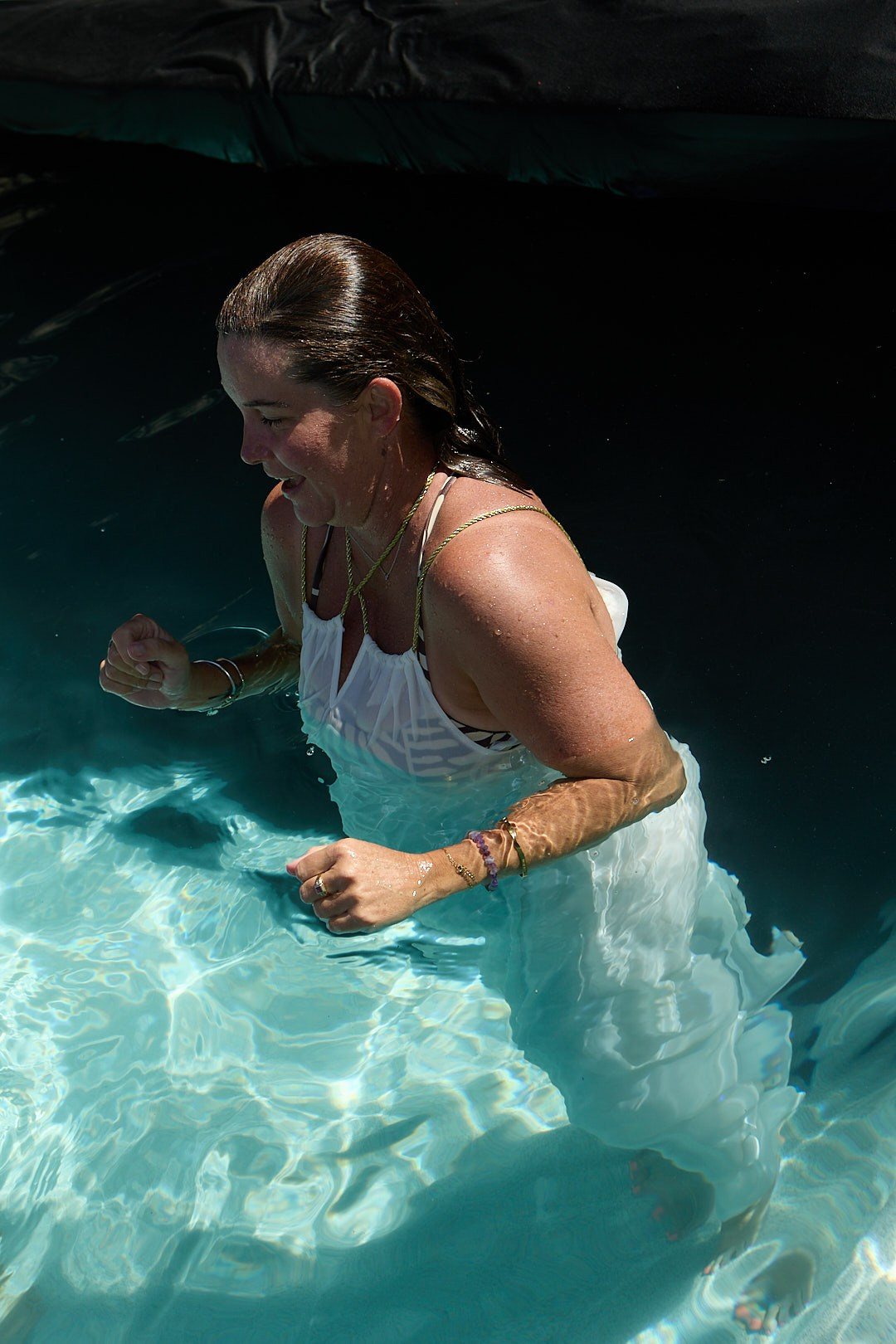 Fashion model in a white swimsuit photographed in a swimming pool during an underwater fashion shoot