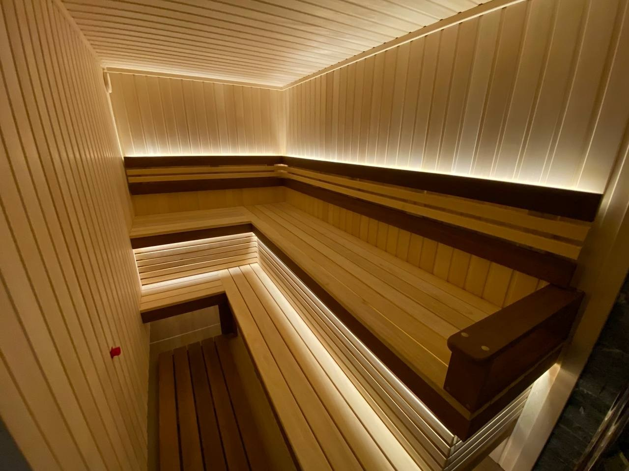 Семейная сауна в Кузьмолово на базе Harvia Glow. В отделку из липы встроены просторные полки из комбинации абаши+ термоабаши. SaunaTopMasters