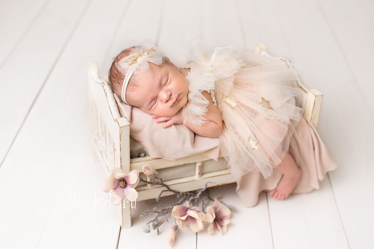 Новорожденная девочка на кроватке