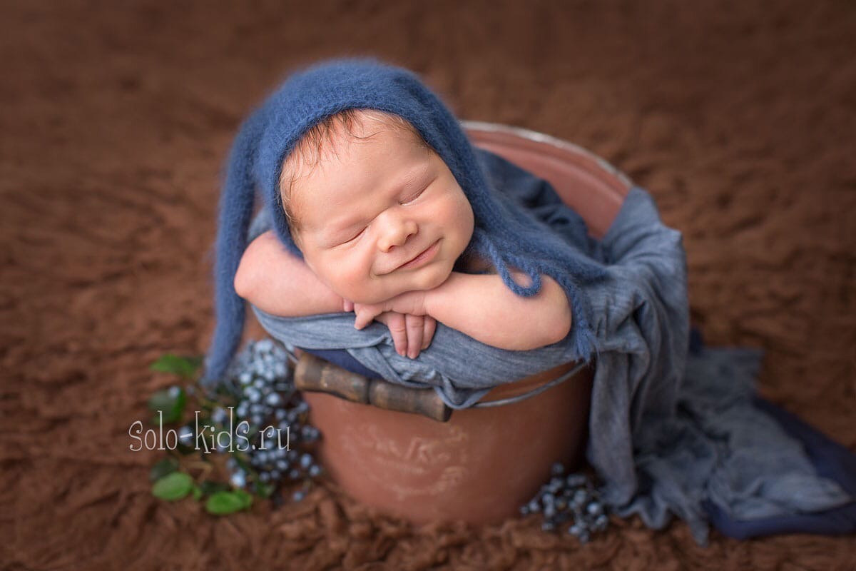 Новорожденный ребёнок мило улыбается во сне