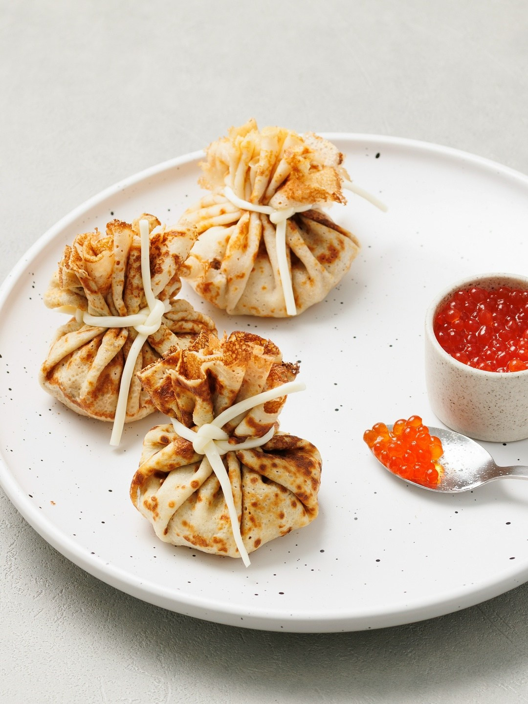 мешочки из блинов с начинкой из красной икры. Фудфото блинов.