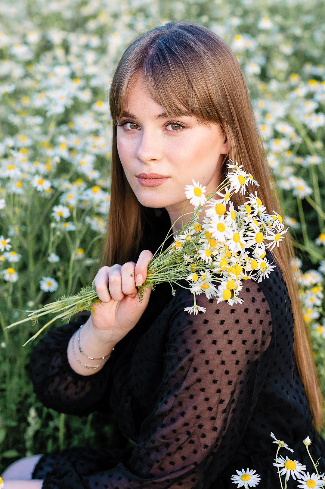 красивая молодая девушка с букетом ромашек
