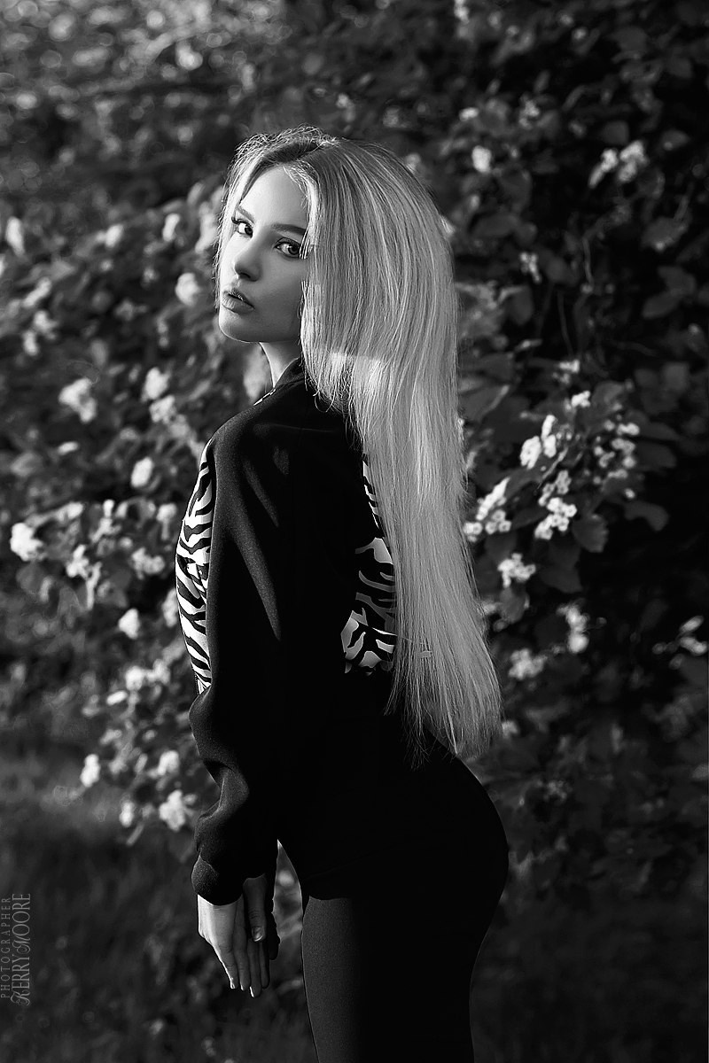 Блондинка стоит возле цветов чёрно белый портрет