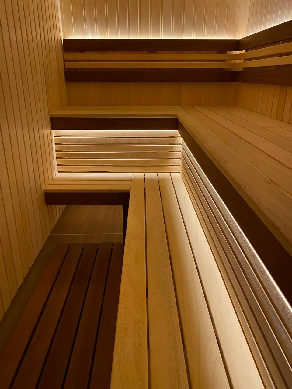 Семейная сауна в Кузьмолово на базе Harvia Glow. В отделку из липы встроены просторные полки из комбинации абаши+ термоабаши. SaunaTopMasters