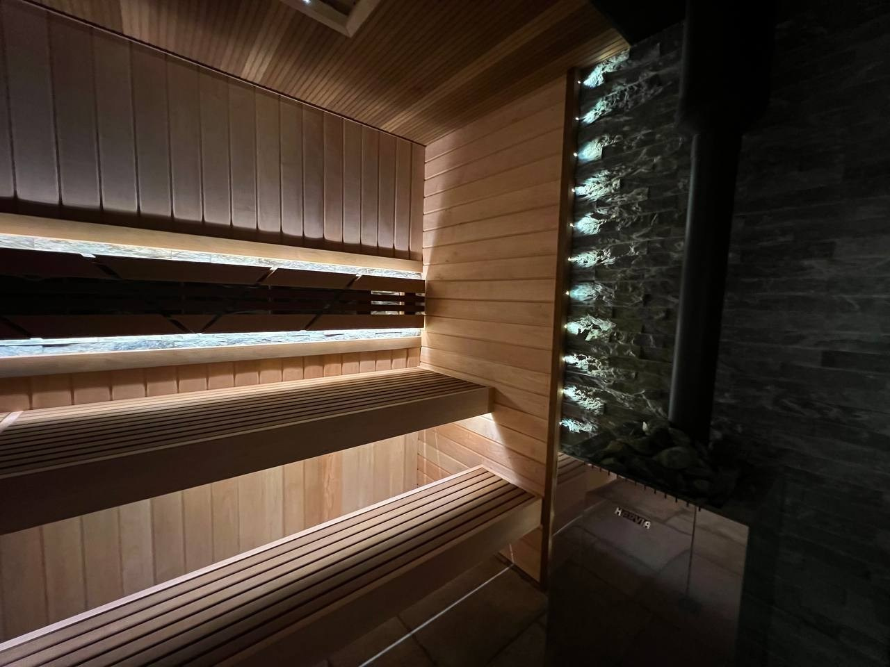 Парная в Лисьем носу с анатомическим пологом и можжевеловым панно, а хромированная печь в свете оптоволокна создает неповторимую атмосферу. SaunaTopMasters