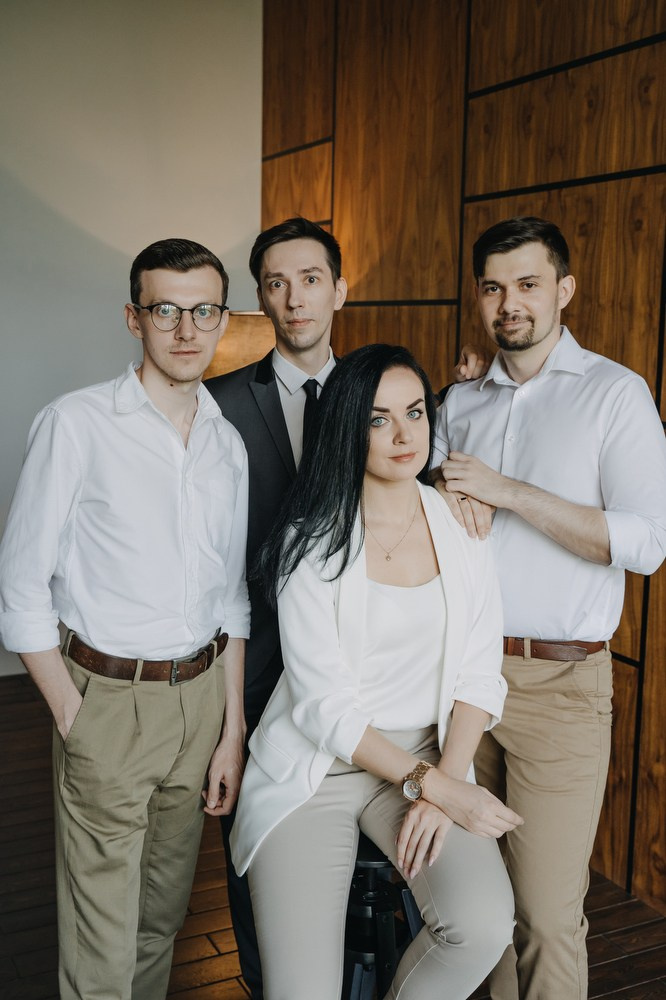 Командное фото сотрудников адвокатского бюро в офисе с дизайнерским интерьером.