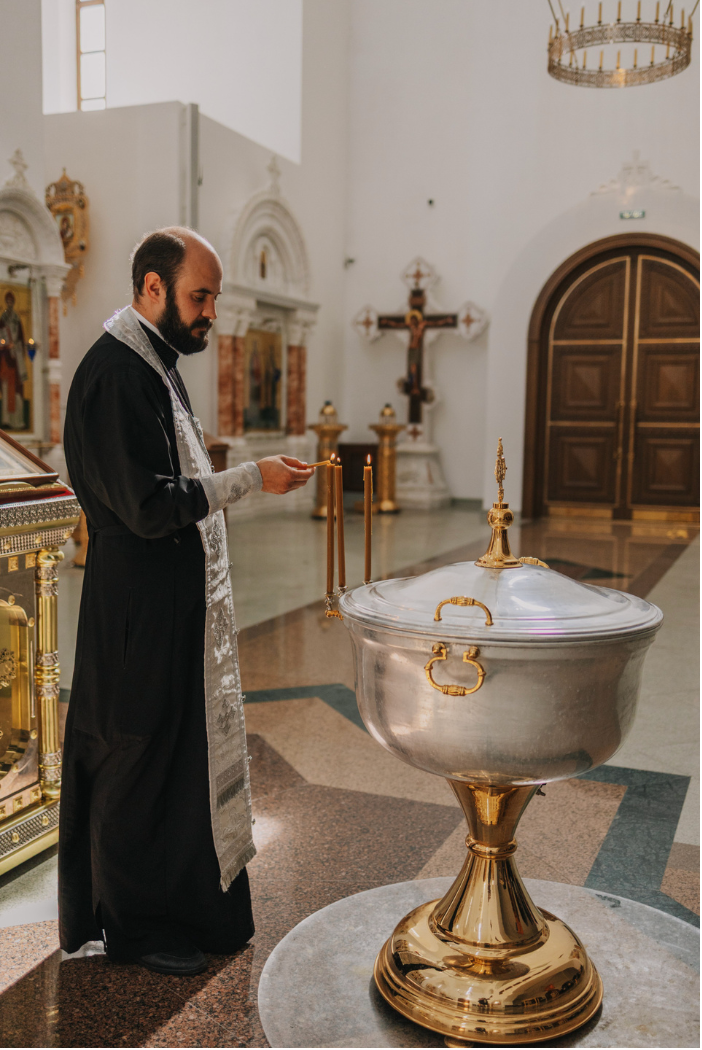 Фотограф на крещение: Репортажный кадр из церкви, батюшка проводит Таинство.