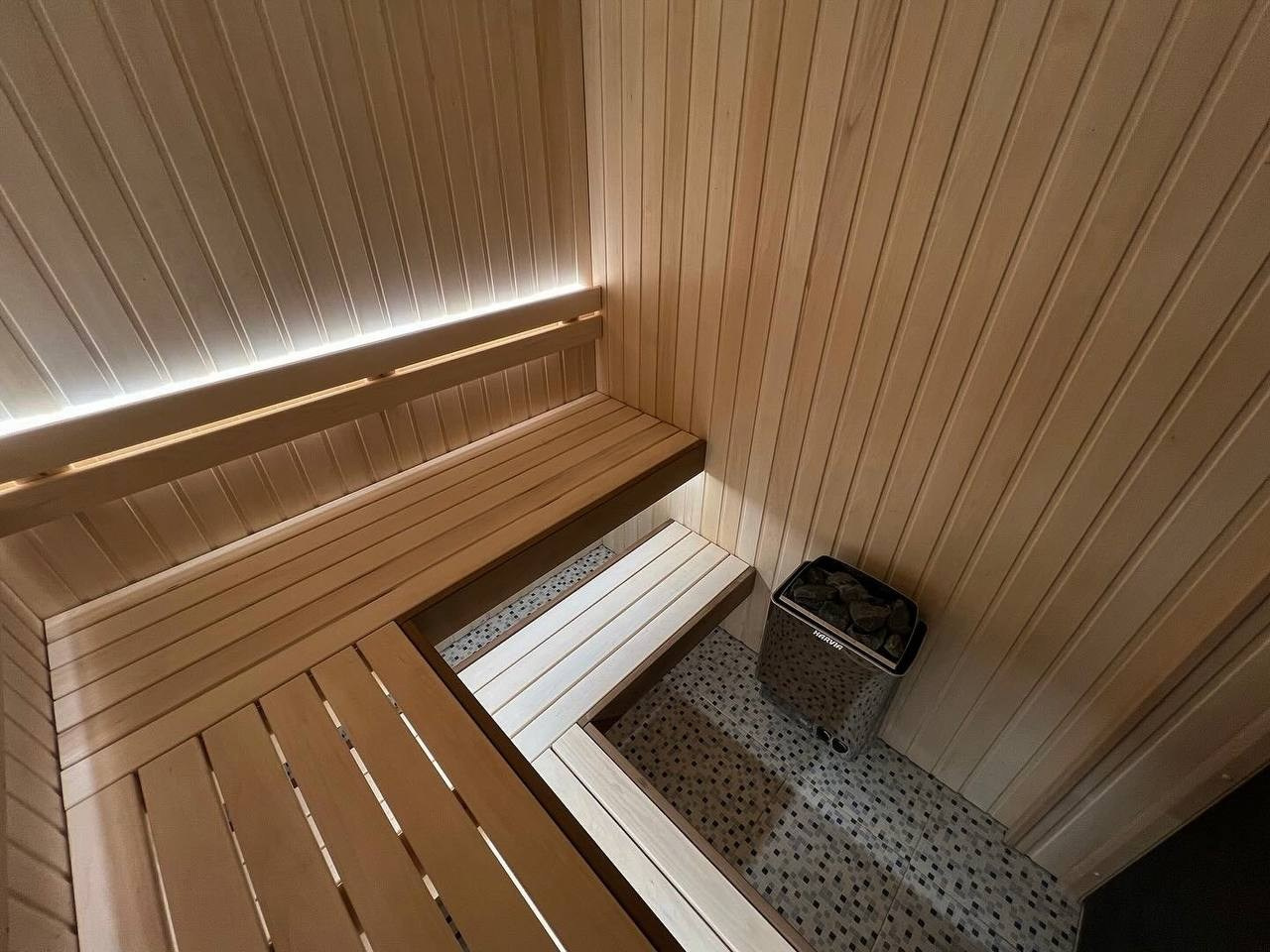 Просторная и светлая сауна в Шаглино выполнена из ароматной липы и африканского абаши, а тепло ей дарит электрокаменка Harvia Trendi KIP. SaunaTopMasters