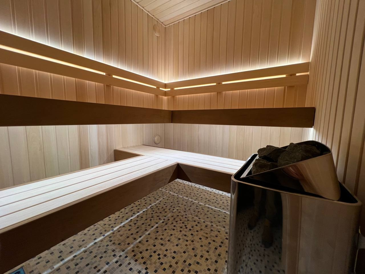 Просторная и светлая сауна в Шаглино выполнена из ароматной липы и африканского абаши, а тепло ей дарит электрокаменка Harvia Trendi KIP. SaunaTopMasters