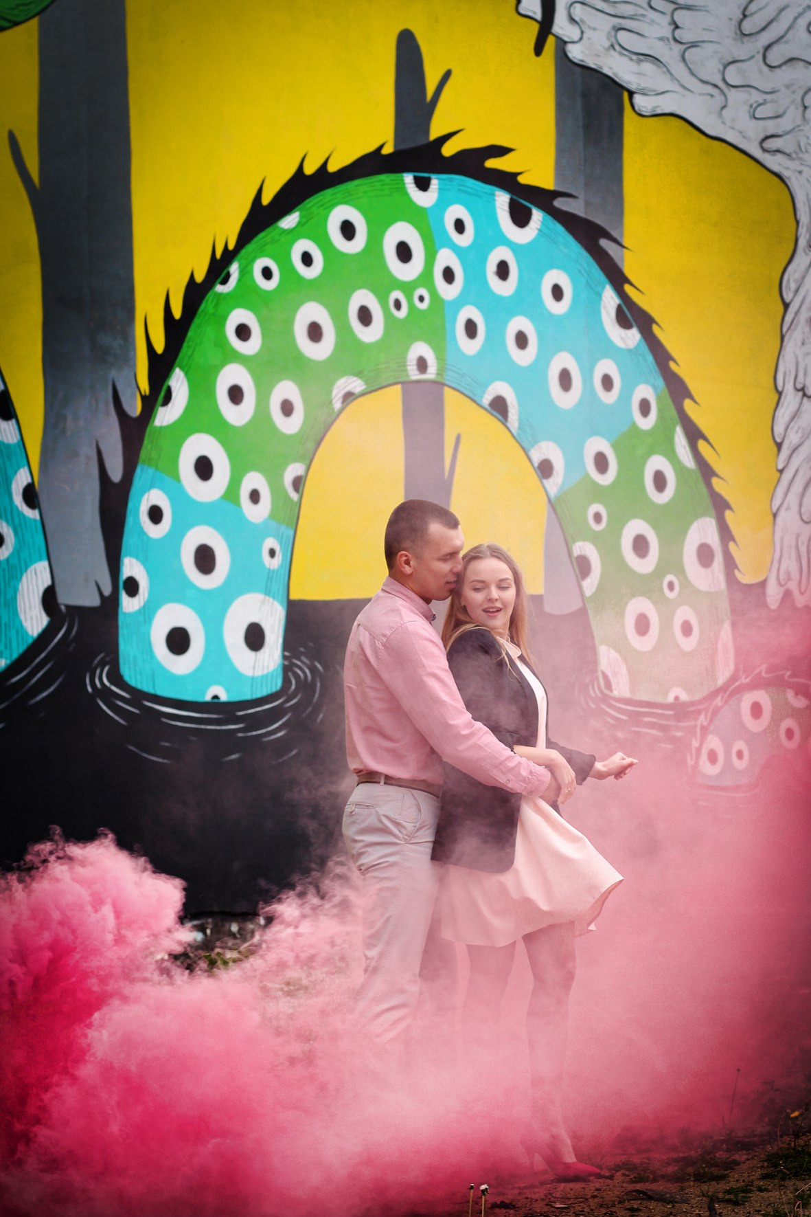 парень и девушка обнимаются в розовом дыму