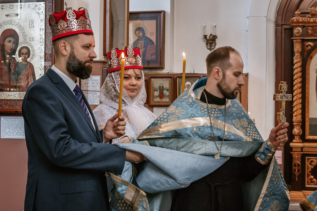 Священник соединяет руки жениха и невесты и обводит молодых три раза вокруг аналоя.