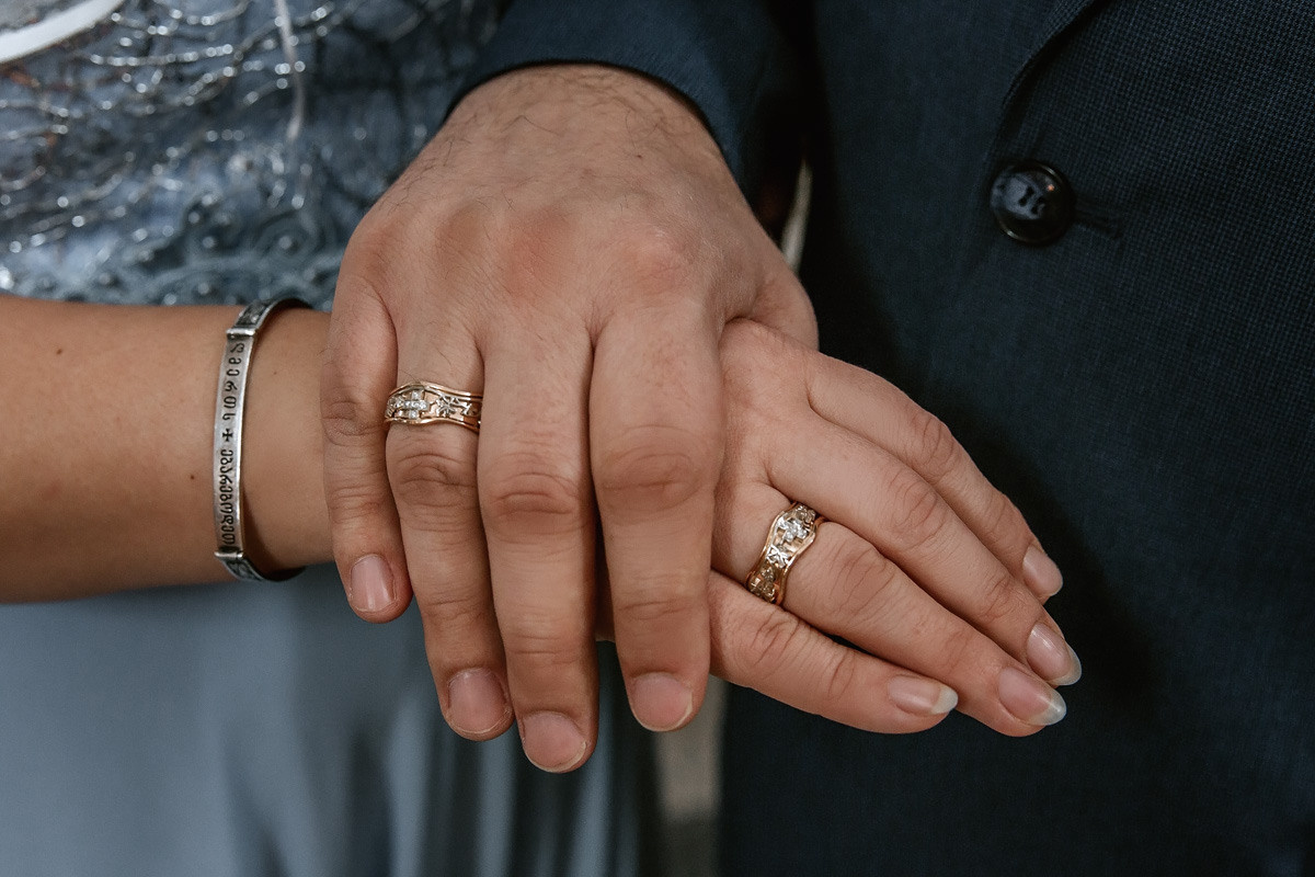 Венчальные кольца на руках супругов.