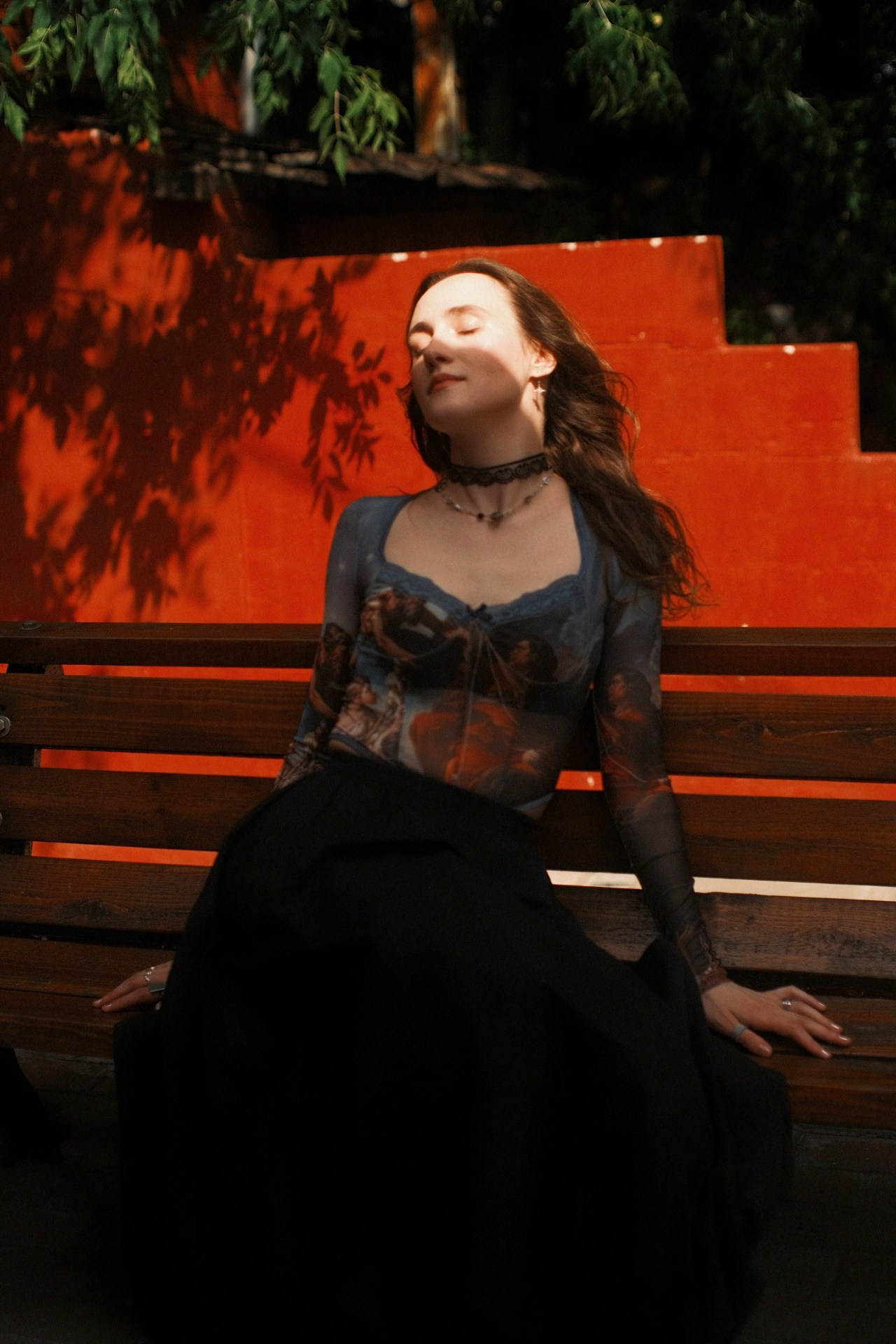 Художественный портрет девушки на скамейке у оранжевой стены с тенями деревьев, принт с классической живописью на топе