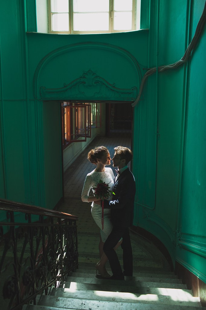 жених и невеста обнимаются в контровом свете на фоне петербургской парадной