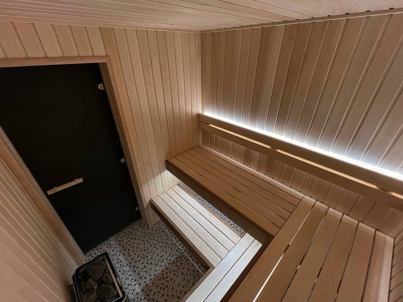Просторная и светлая сауна в Шаглино выполнена из ароматной липы и африканского абаши, а тепло ей дарит электрокаменка Harvia Trendi KIP. SaunaTopMasters