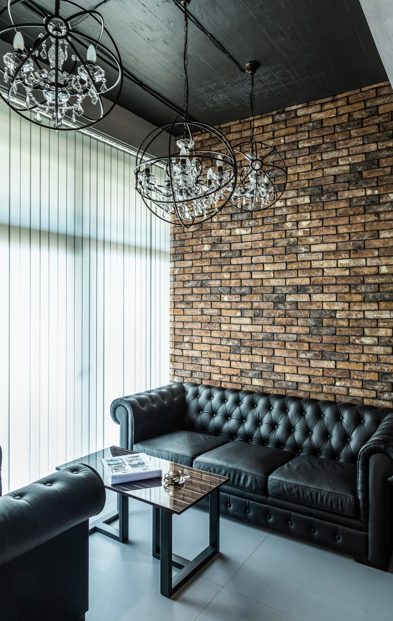 Черные кожаные диваны со стеклянным столиком.