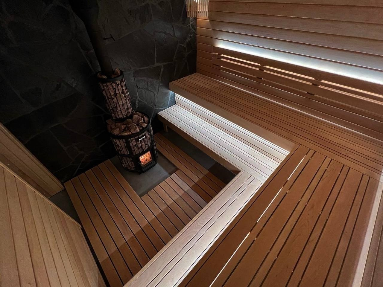Эксклюзивная парная в Мендсарах из разнокалиберной светлой ольхи и шунгита, а внутренняя топка только усиливает эффект контраста. SaunaTopMasters
