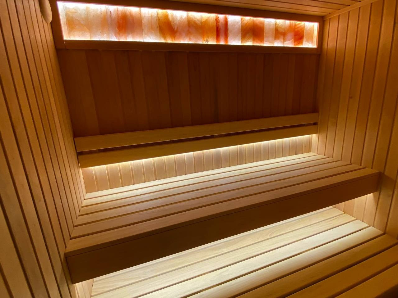 Компактная сауна в Охте: ольха, парящие полки, солевая линия 200 мм на базе электрокаменки Harvia Vega — максимум уюта в малом формате. SaunaTopMasters