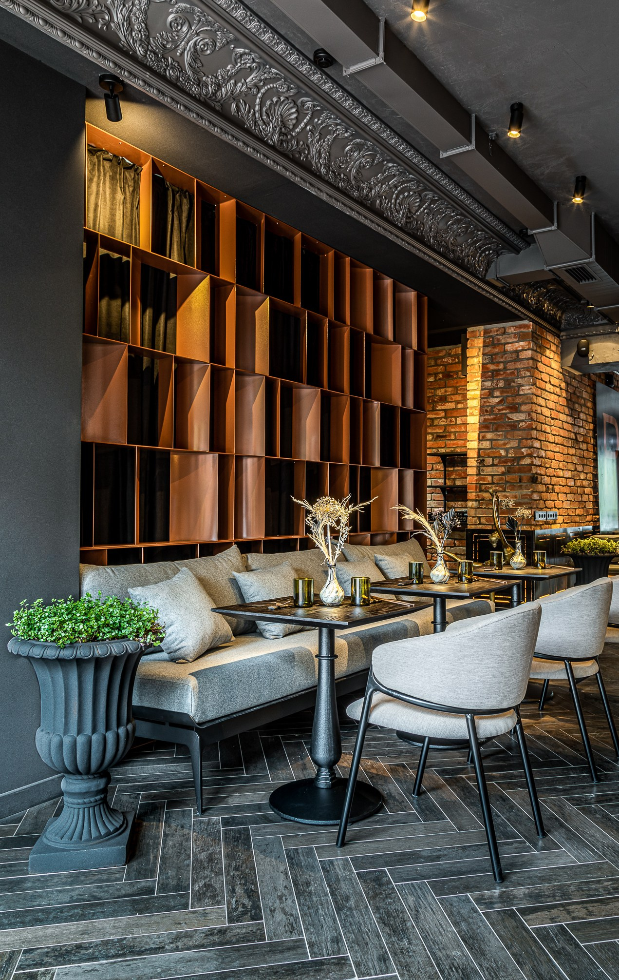 Темные столы с диваном и бежевыми стульями из ткани.