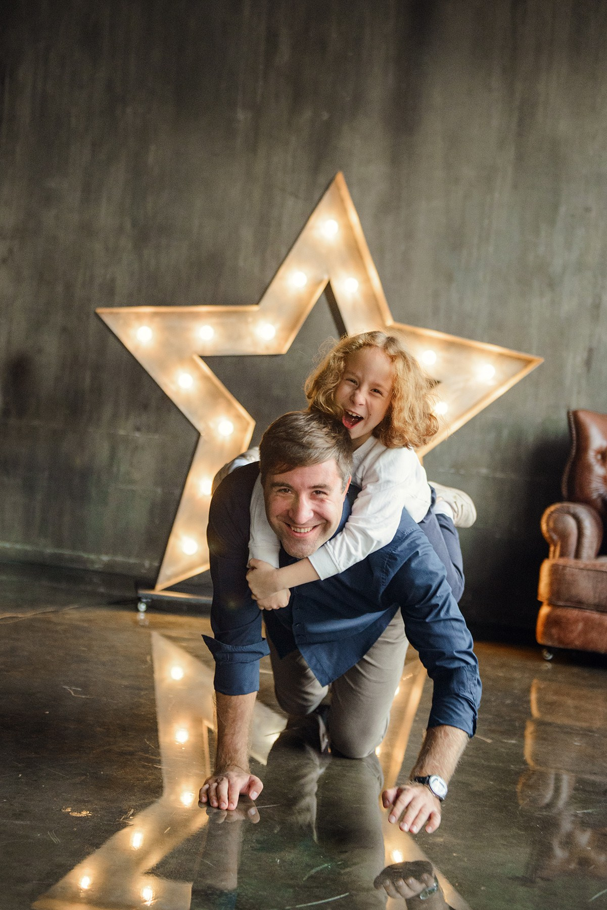dad and daughter in a dark photo studio