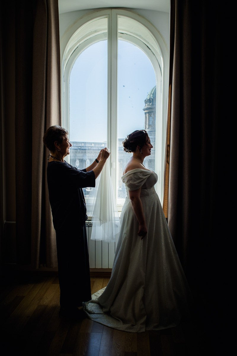 Мама невесты надевает ей фату