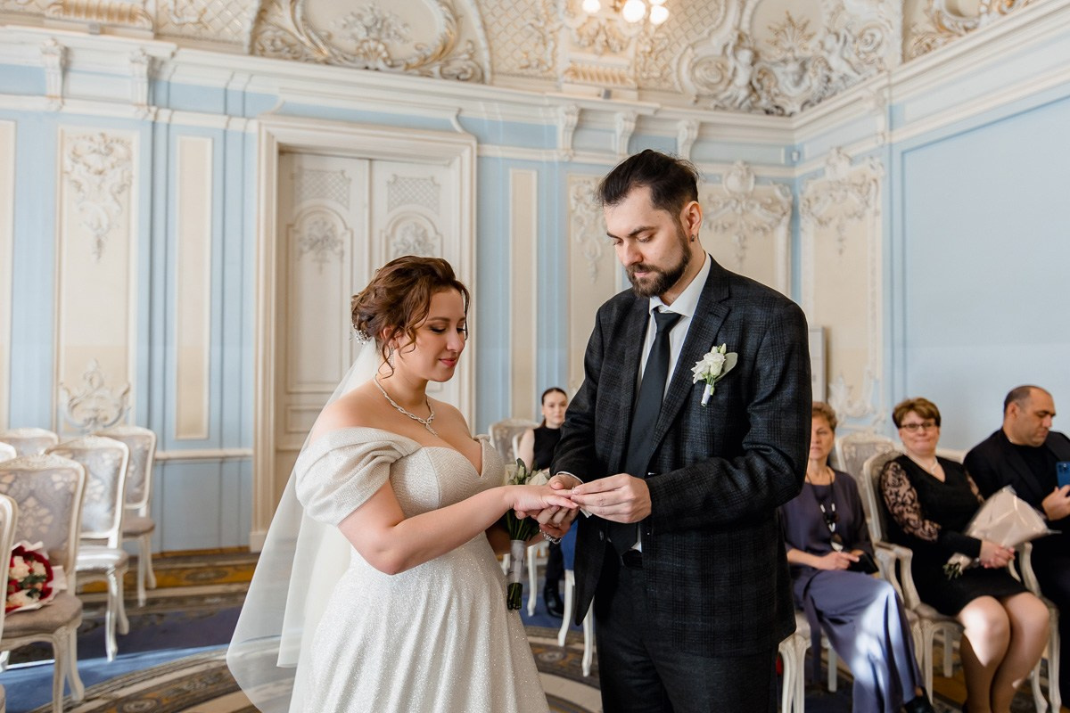 Жених и невеста в зале регистраций в ЗАГСе на фурштатской СПб обмениваются кольцами. Горизонтальный кадр