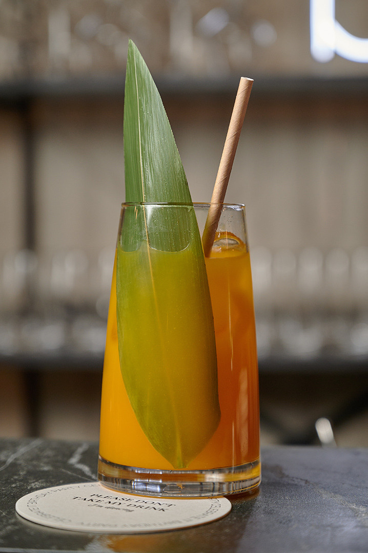 безалкогольный лимонад с соломинкой в бокале и зеленым листом