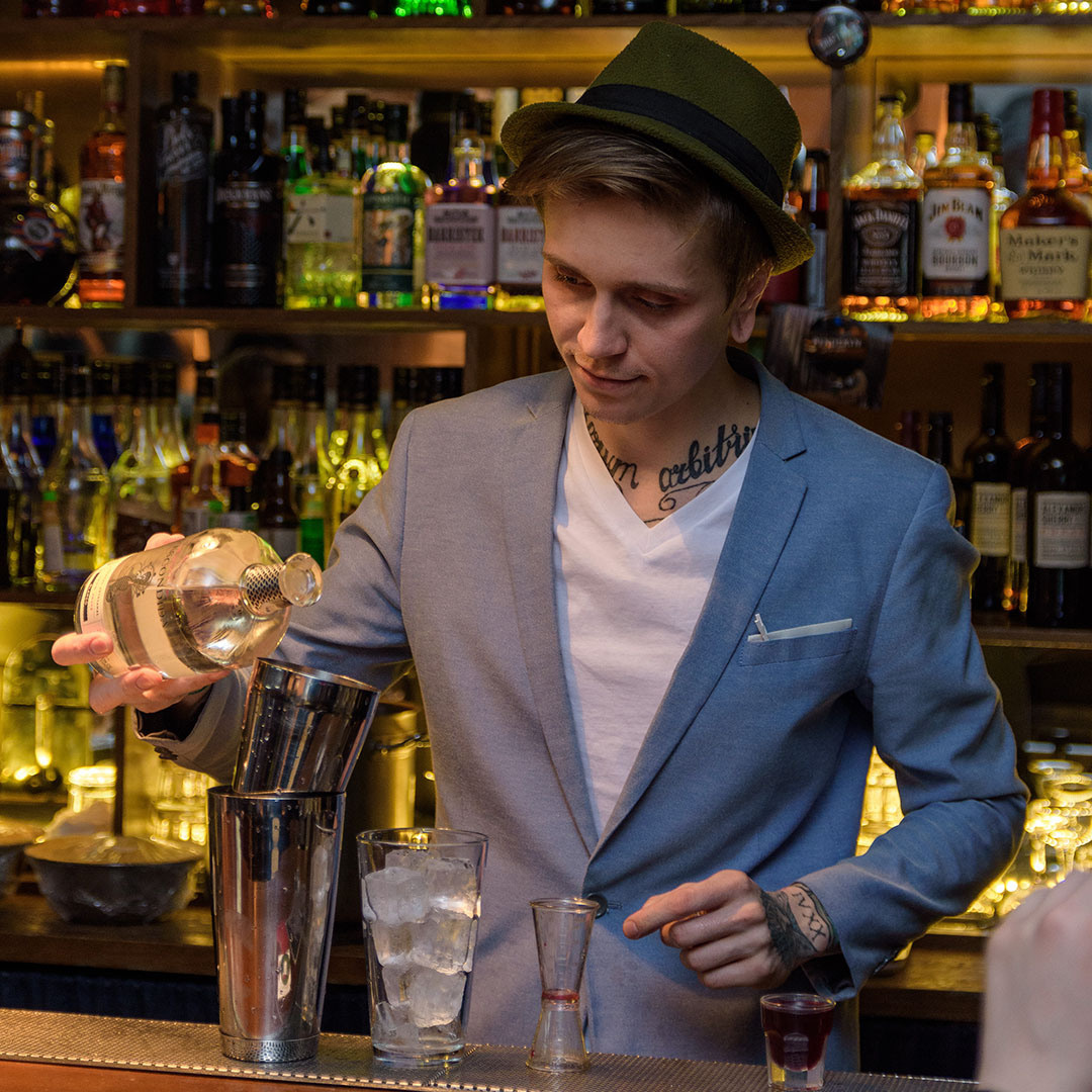 бармен наливает алкоголь в баре