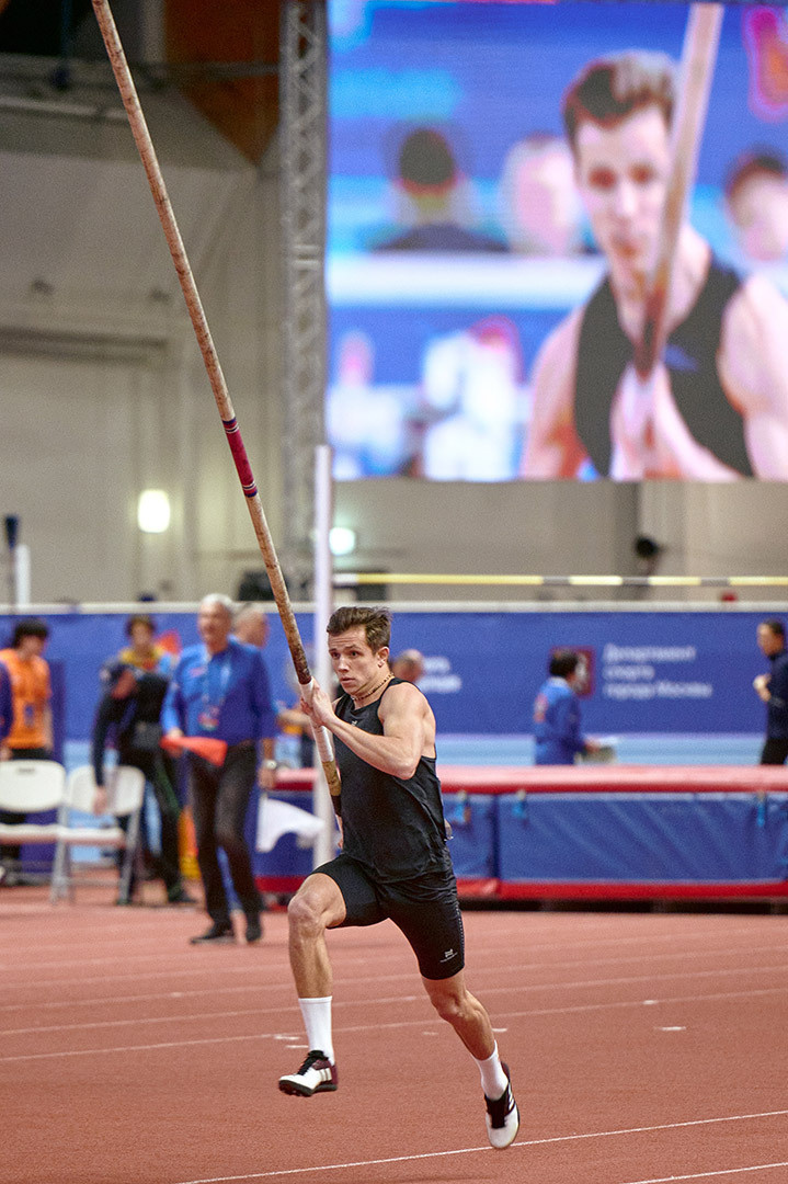 Спортивные Состязания, атлет бежит с шестом готовится к прыжку
