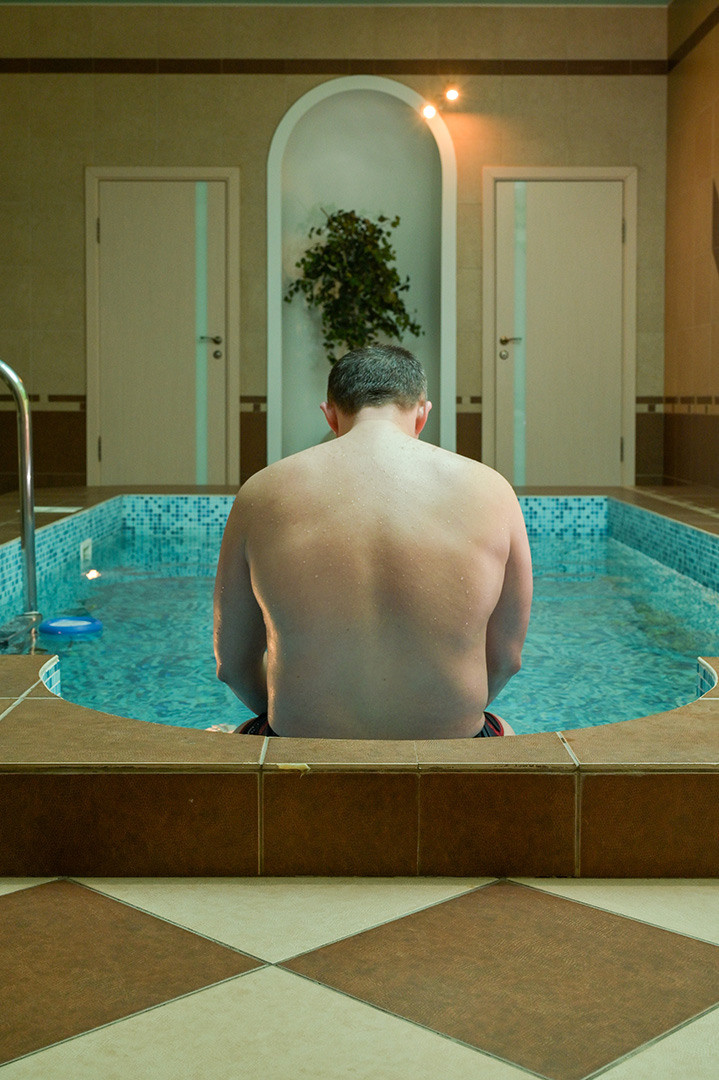 интерьер сауны с бассейном внутри сидит мужчина