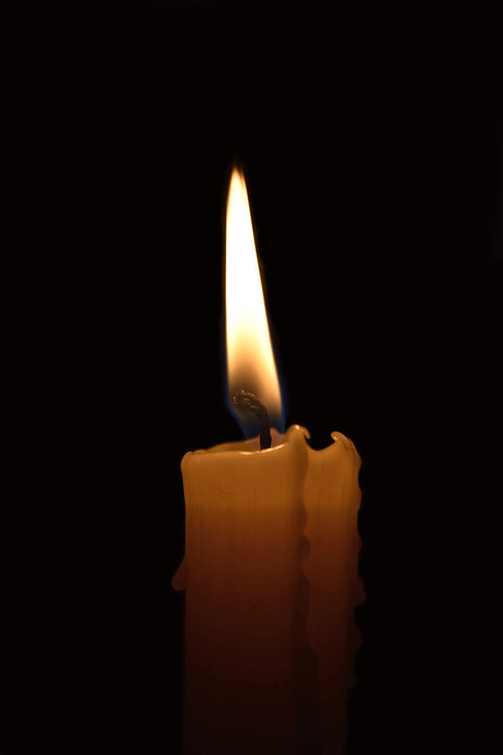 рекламная фотография, горящяя свеча на черном фоне