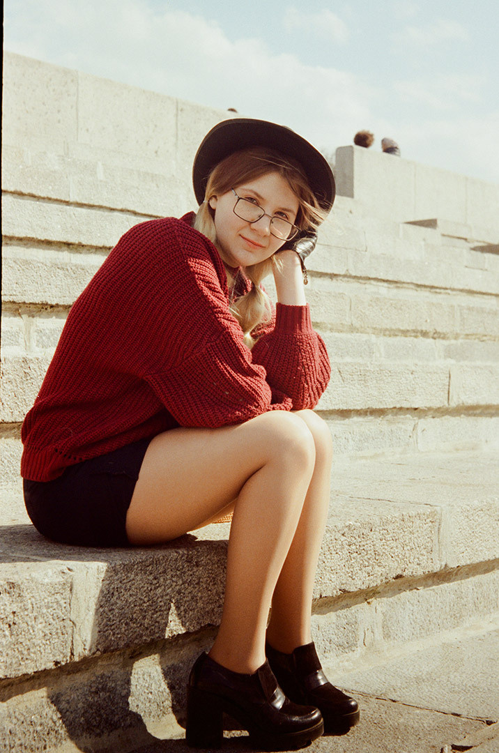 красивая девушка в шляпе позирует на набережной в Москве