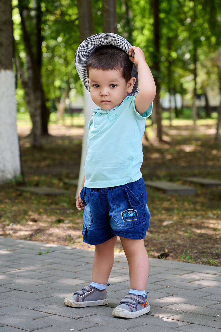 семейная фотосессия, молодой мальчик в шляпе в парке