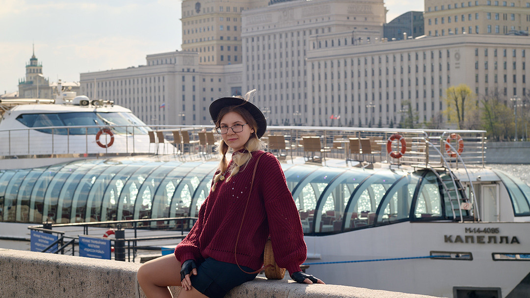 Девушка фотографируется на фоне корабля