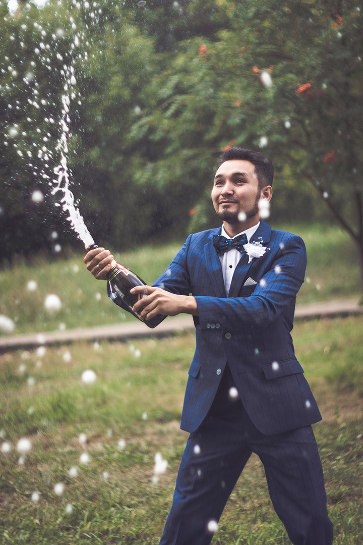 Свадебная фотосессия, жених открывает бутылку шампанского