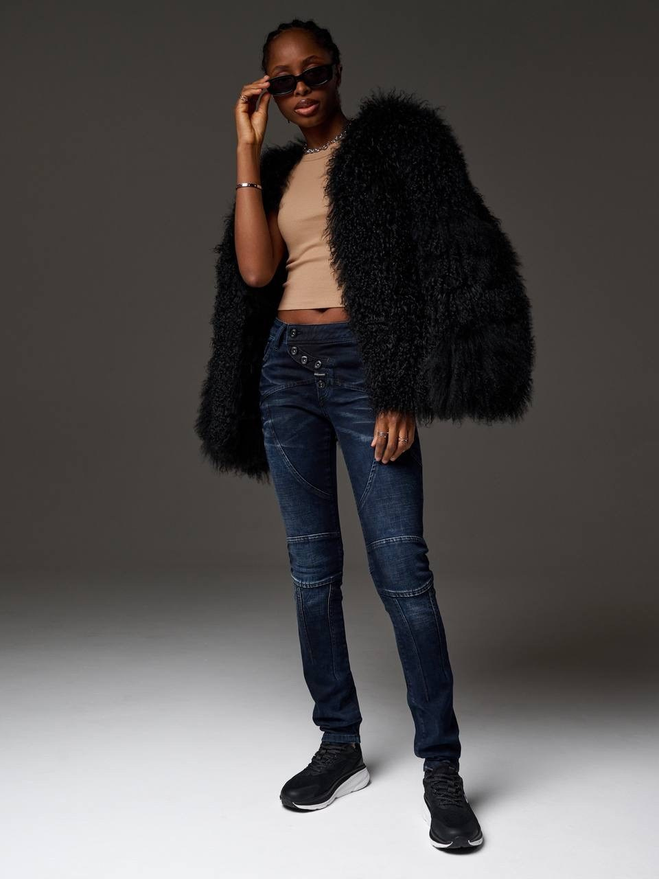 Фотосессия для бренда одежды - модель мулатка в джинсах и шубе на очень темной циклораме