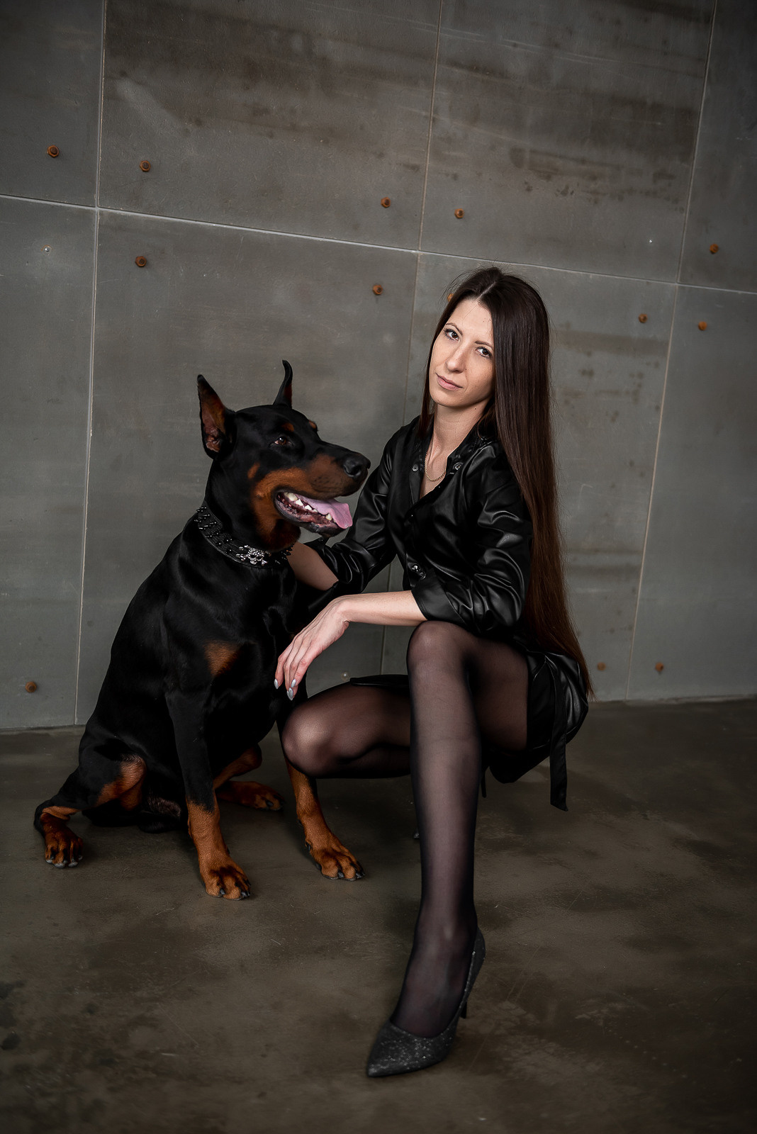 Фотосессия  с доберманом, фотосессия с собакой, доберман, девушка, фотосессия в студии, студийная фотосессия, собака на фотосессию, фотограф, фотограф в новосибирске. Девушка в черном кожаном платье с доберманом, на фоне бетонной стены, фотограф новосибирск, фотосессия новосибирск, заказать фотографа в новосибирске, портретный фотограф новосибирск, женский фотограф новосибирск