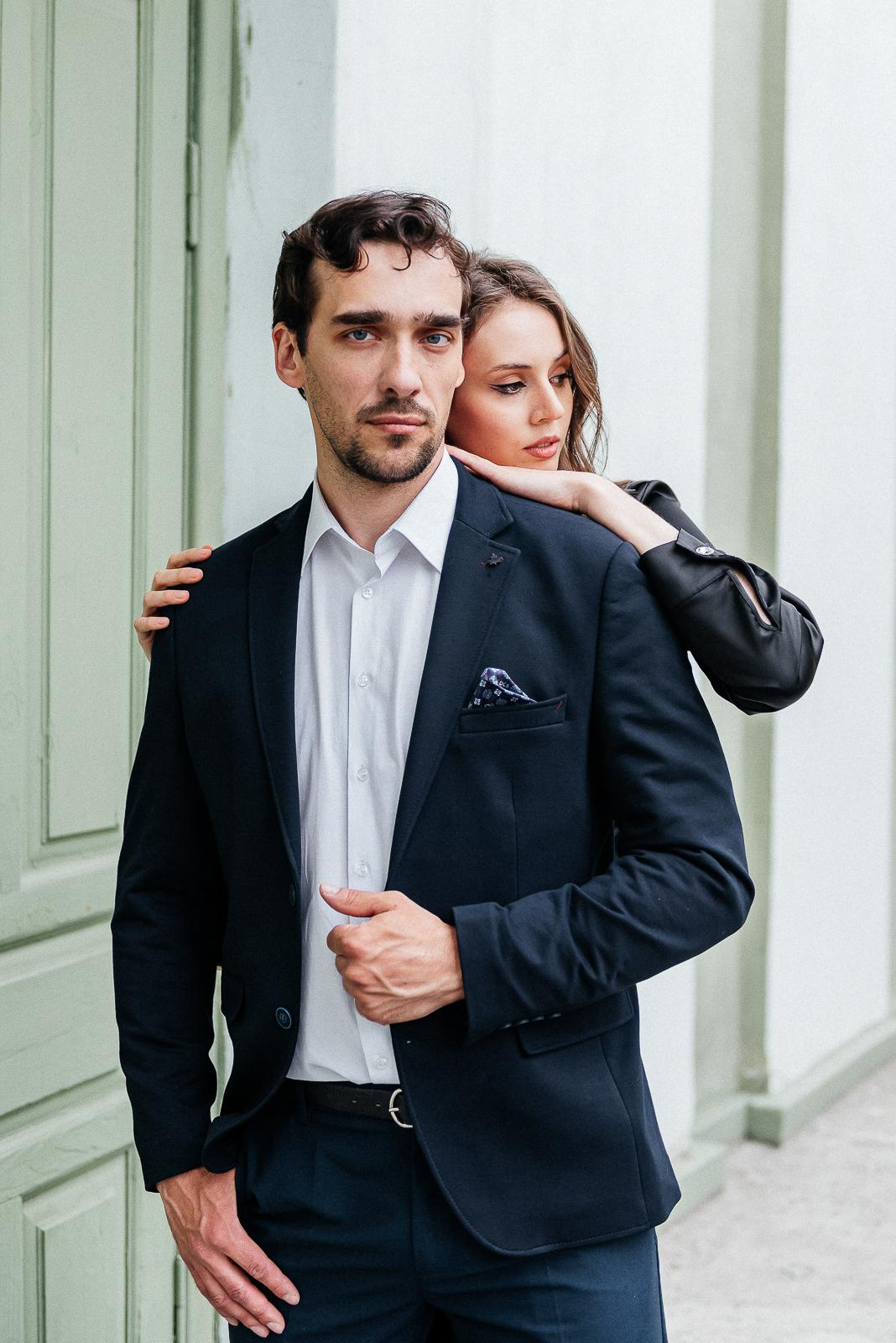 парень в костюме стоит впереди, девушка обнимает парня, фотосессия в городе, история любви, фотограф новосибирск