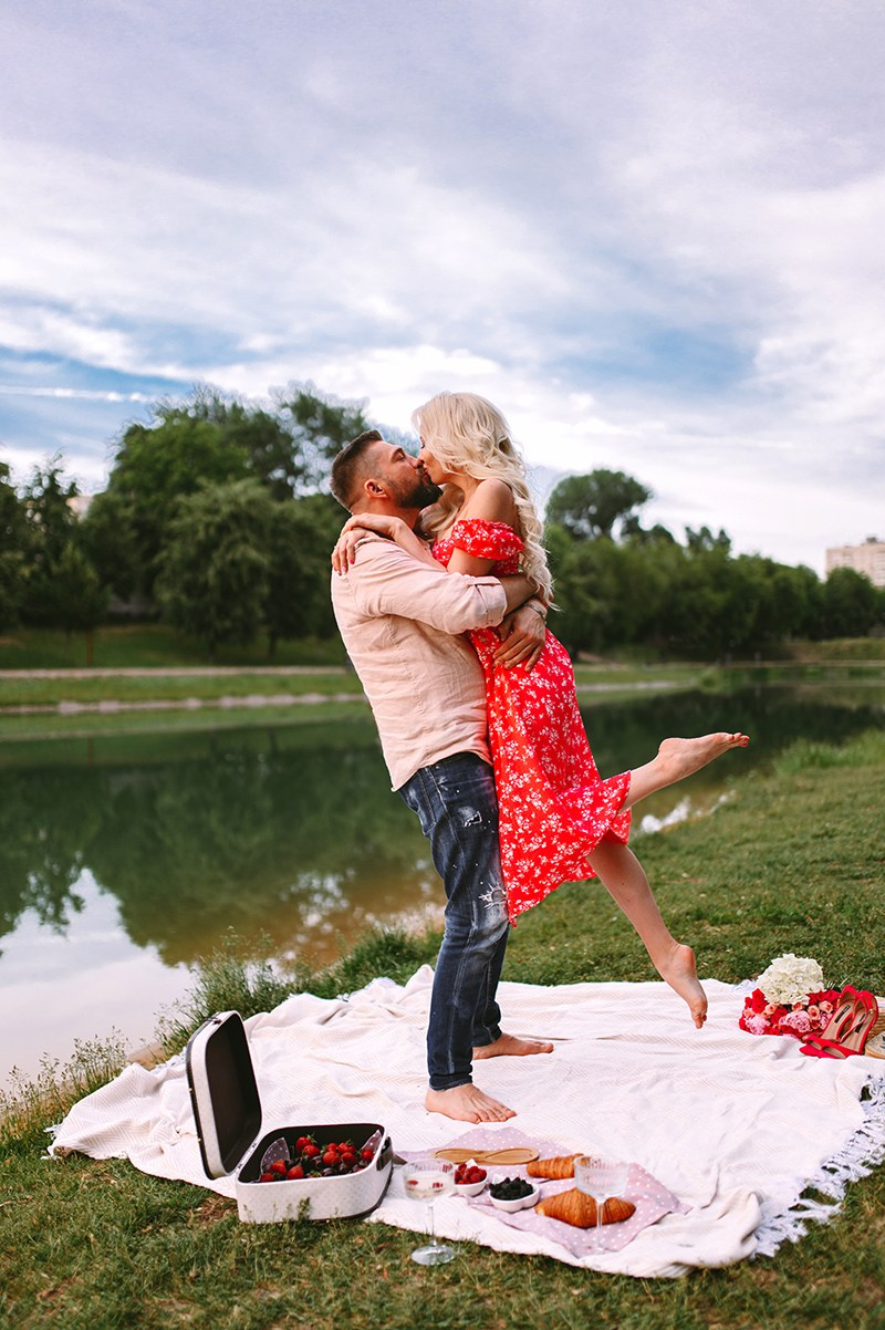 Пара обнимается у озера на природе во время лав стори фотосессии