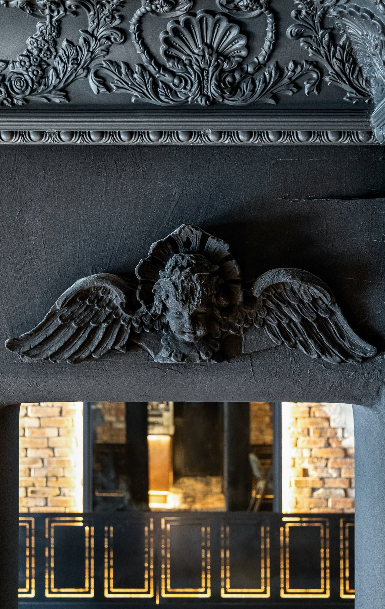 Лепнина на стене покрашенная в глубокий серый цвет.