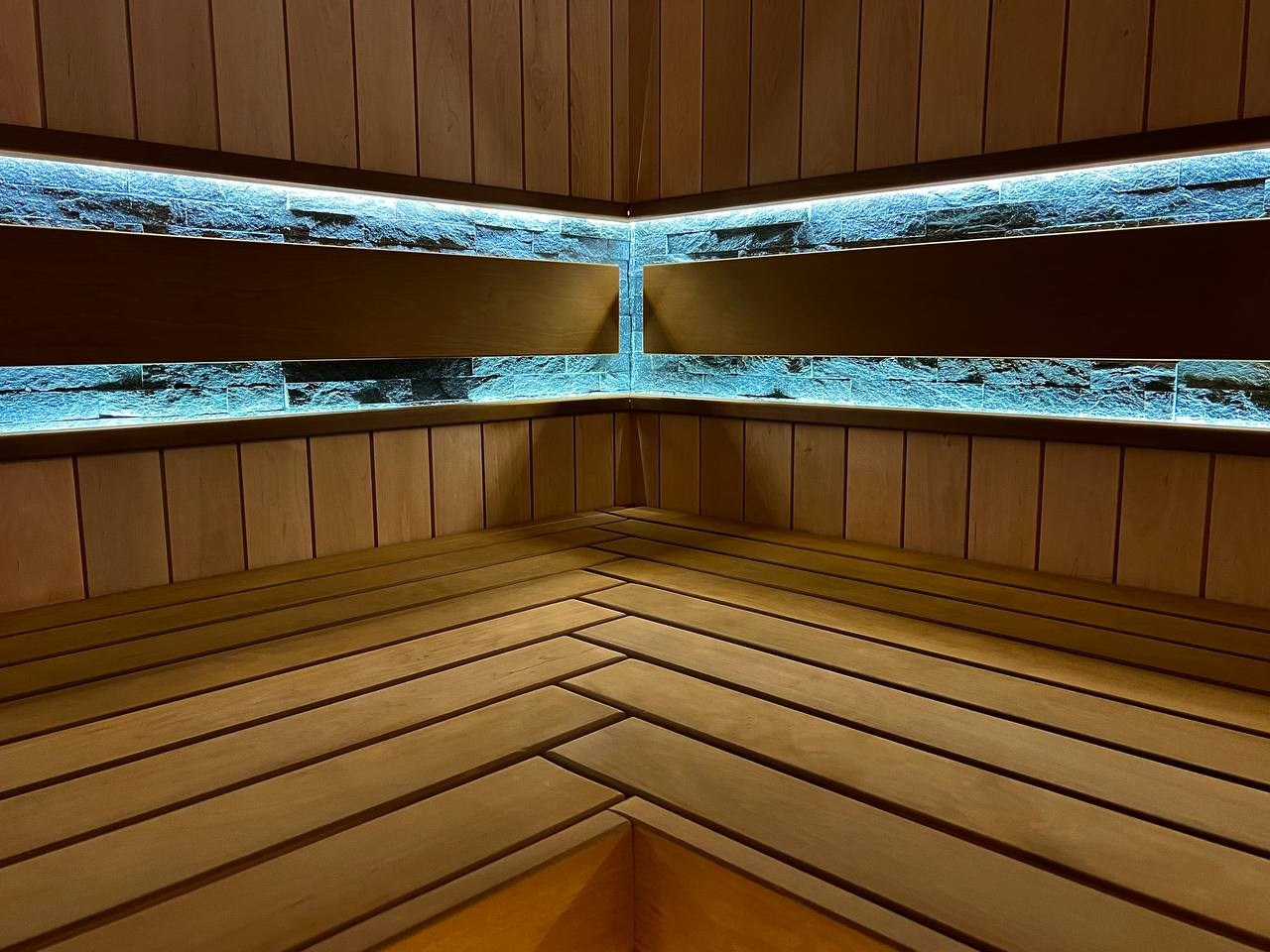 Просторная сауна в Сертолово из термоольхи с интеграцией можжевеловых линий и большого количества натурального камня. SaunaTopMasters