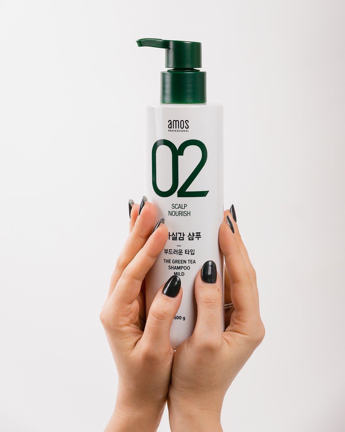 Флакон косметики для волос держат две руки на белом фоне