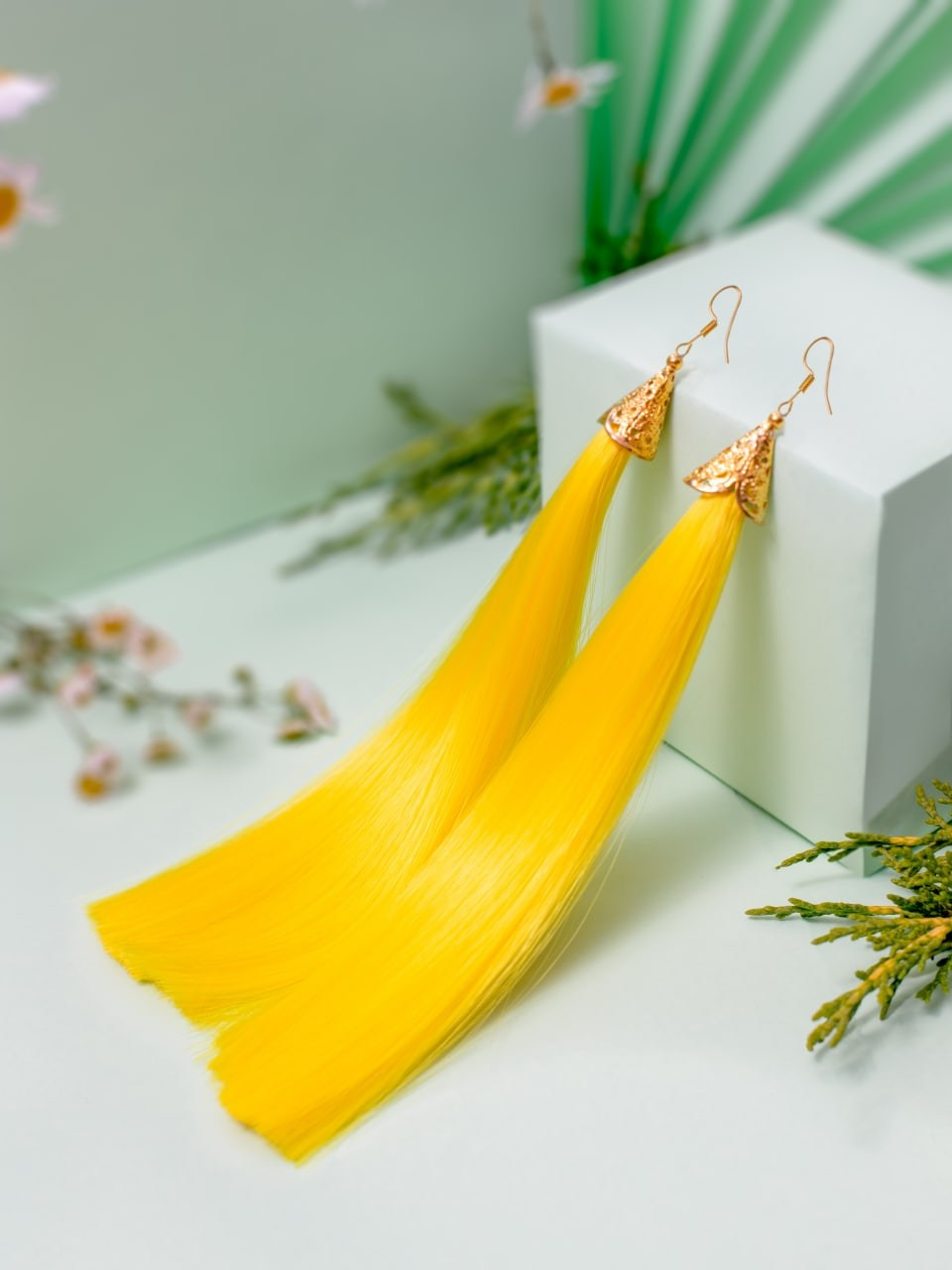Предметная съёмка — серьги с прядями волос жёлтого цвета.