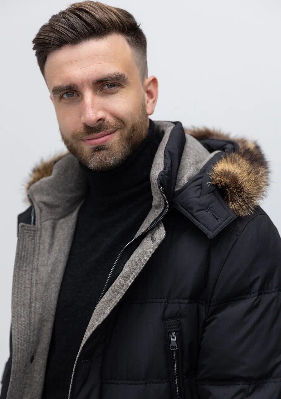 Мужчина с бородой в теплой стеганой куртке с капюшоном