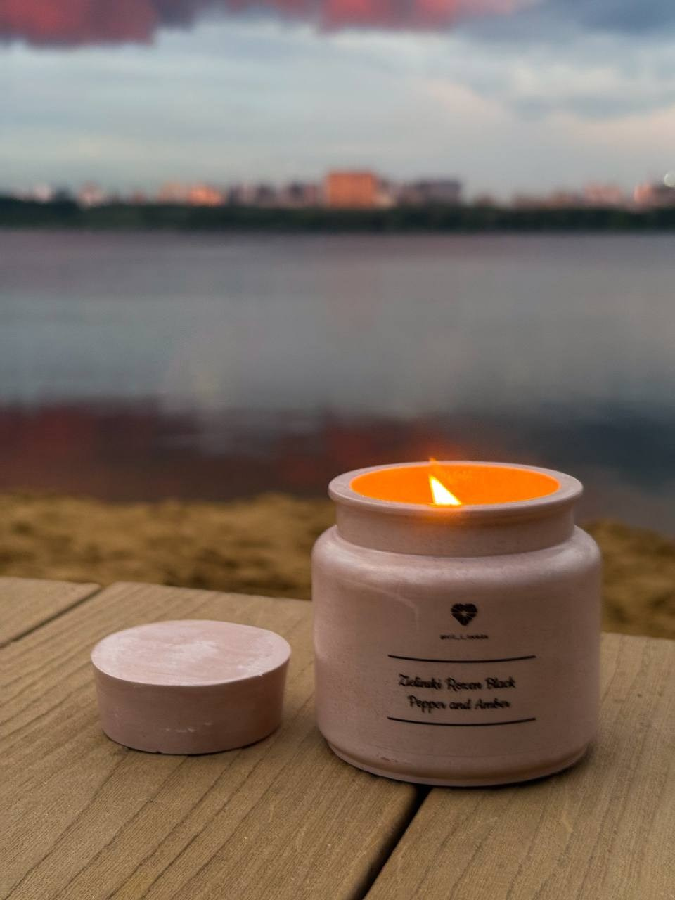 Мини-съёмка свечи в баночке на фоне заката — каталожное фото.