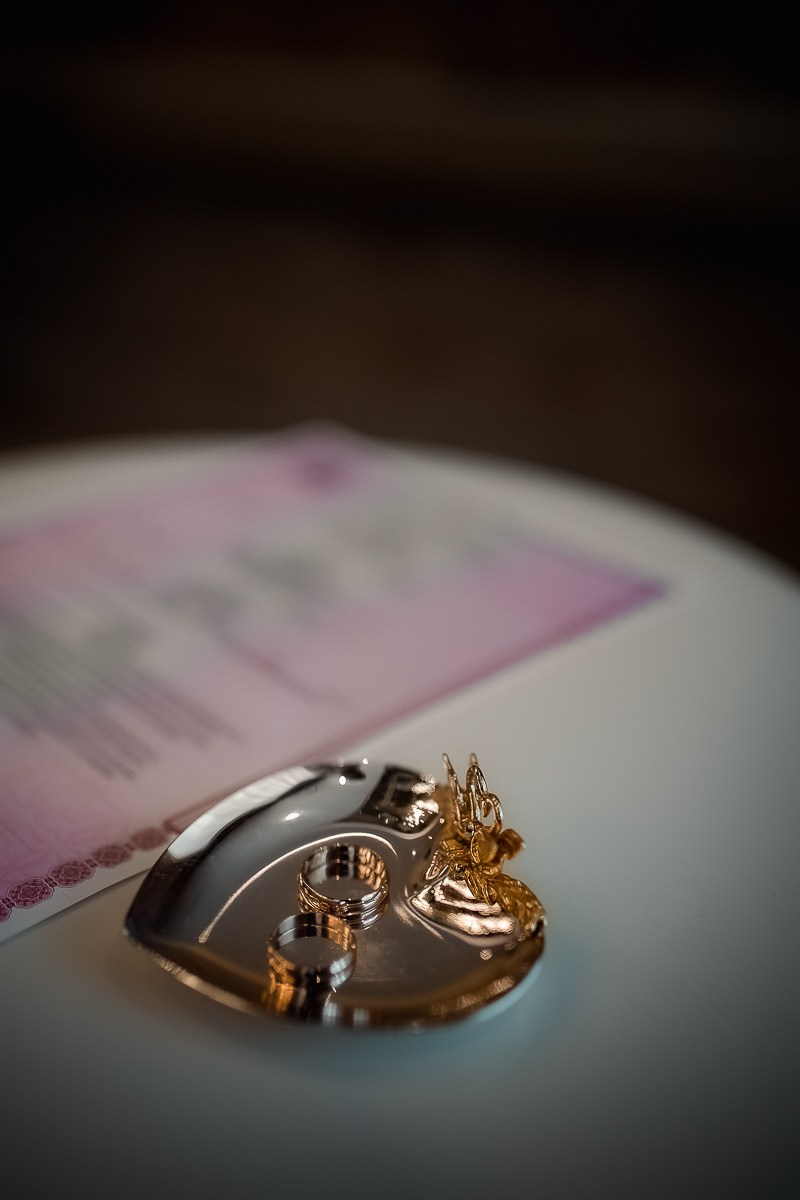 Кольца на столе регистратора в ЗАГСе на Васильевском острове в Санкт-Петербурге. Вертикальный поясной кадр.